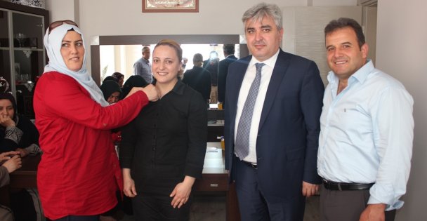 AK Parti'ye katılan aileye rozet taktı
